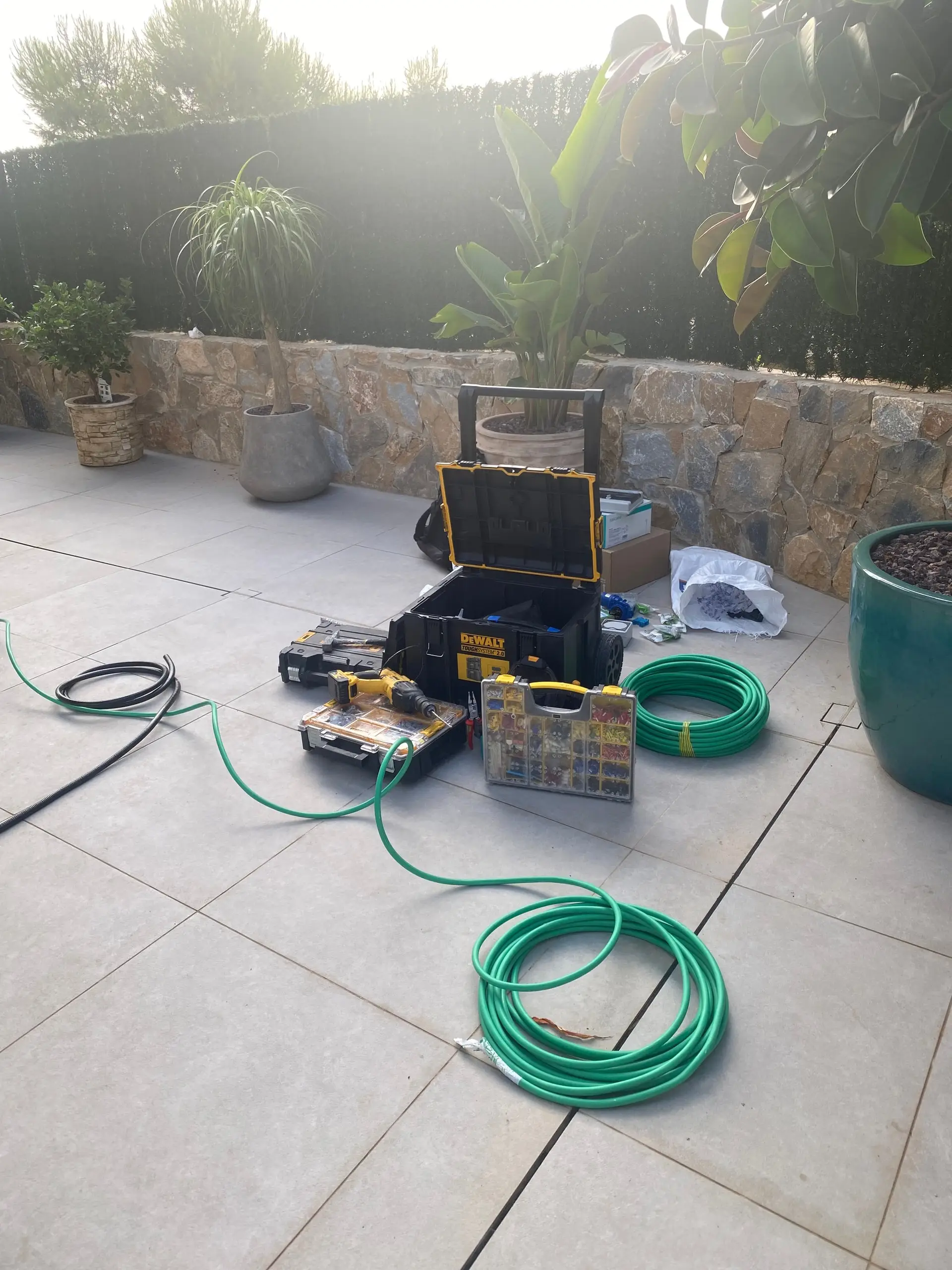 Tools and cable drums laid out on a house terrace before the installation starts