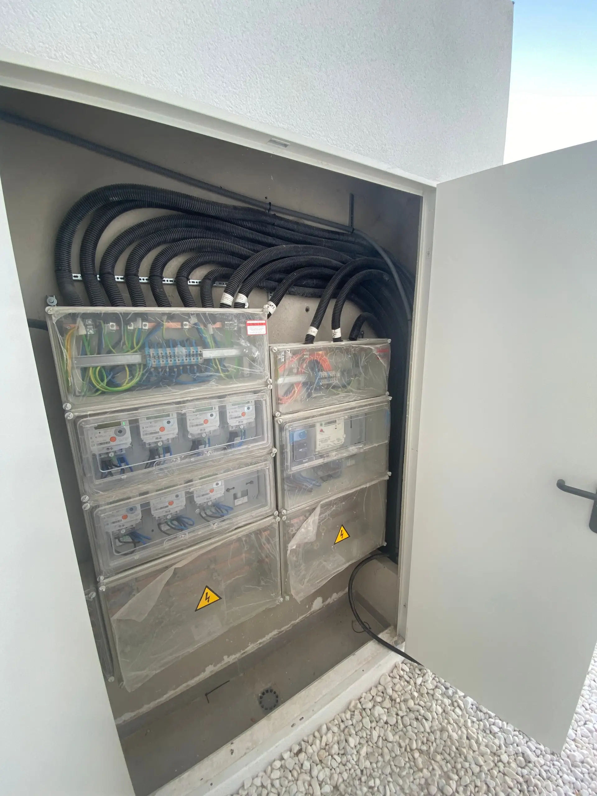Open meter cabinet showing the metering units and the corrugated conduits of the supply lines