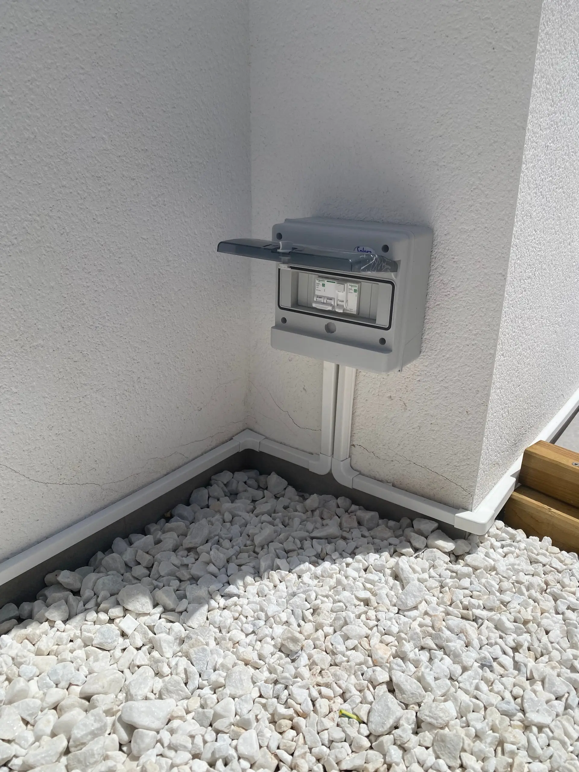 Closed surface-mounted weatherproof enclosure with two protective devices and white containment in the corner
